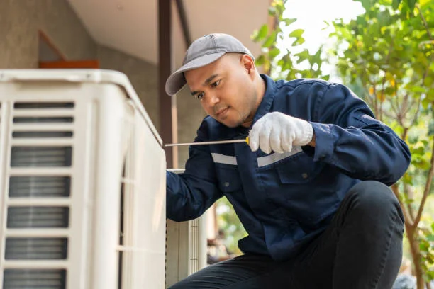 HVAC technician inspecting an outdoor air conditioning unit