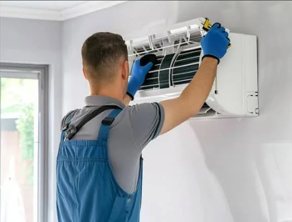 HVAC technician servicing a wall-mounted ductless cooling system