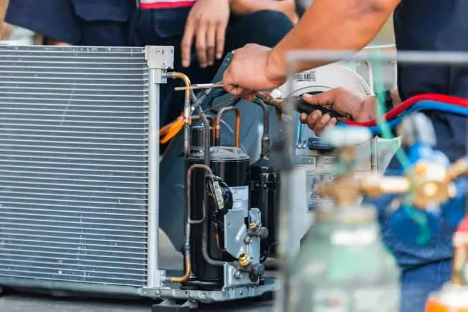 Technician repairing internal components of an air conditioning system