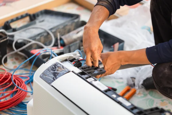 Hands servicing internal heating and cooling equipment components