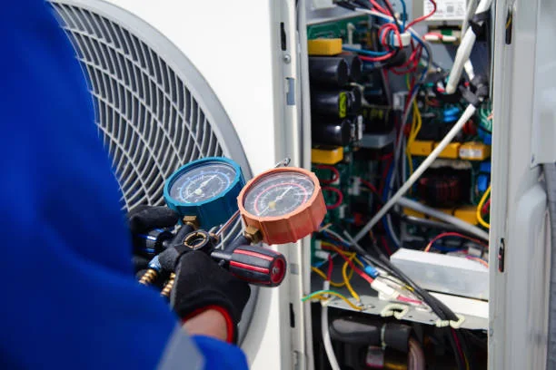 Technician checking HVAC system pressure gauges during maintenance